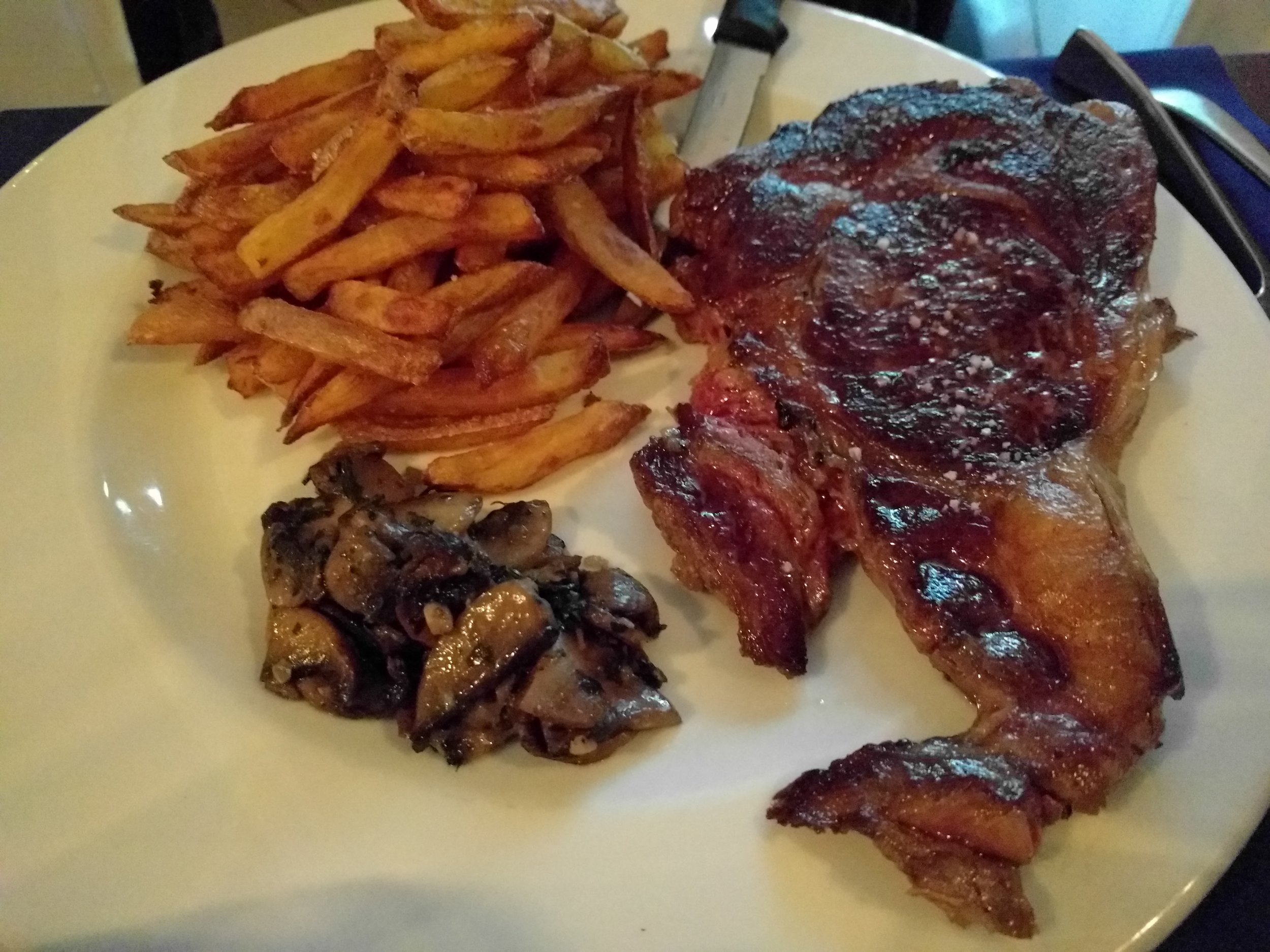 Ribeye with fries and mushrooms at Le Jardin
